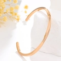 Bracelet jonc ouvert spirale en or rose poli présenté sur une pierre de marbre - Or Rose Femme