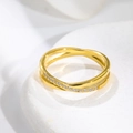 Macro shot of rose gold criss cross ring featuring a row of white pavé set diamonds - US 5 / Gold