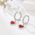 Close-up of heart-shaped drop earrings with red center and sparkling pavé setting - Red-Steel
