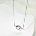 Elegant silver knot pendant necklace in titanium steel on a white ceramic display stand - Silver (B329)