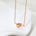 Minimalist rose gold titanium knot necklace with a delicate cable chain on white decor - Rose Gold (B329)