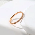 Détail d'un bracelet jonc en or rose avec une rangée élégante de zircons sur pierre - US 6 / Or rose