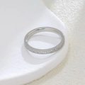 Detailed view of silver stainless steel eternity ring with cubic zirconia on a white tray - US 5 / Steel