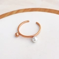 Détail d'une bague ouverte en or rose avec une perle blanche et une bille en métal - US 5 / Or rose