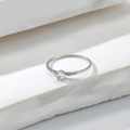 Macro shot of silver ring featuring a classic round-cut diamond in a four-prong setting - US 5 / Silver