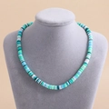 Bohemian clay bead necklace in ocean blue and green tones on a display bust - Green