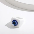 Macro view of white resin square ring featuring a blue evil eye design with silver glitter - Fixed Size / White