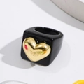 Detailed shot of a black resin wide band ring with a 3D gold heart accent in Y2K style - Black