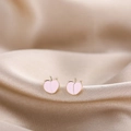 Macro shot of pink enamel peach stud earrings on a silk background for a soft aesthetic - Pink Peach