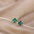 Macro shot of green enamel four-leaf clover stud earrings on champagne silk background - Green Four-leaf Clover