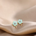 Macro shot of mint green enamel flower stud earrings with a sparkling rhinestone center - Green Flower