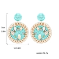 Détail de boucles d'oreilles en perles colorées avec étoile de mer et cadre en rotin - Conque Bleue