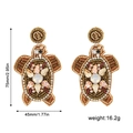 Détail de boucles d'oreilles tortue en perles faites main avec cristaux et taille 75mm - Tortue Marine Dorée