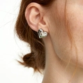 Pendientes de corazón minimalistas en plata mostrados en modelo para un estilo elegante - Pendientes de Corazón de Acero de Titanio Plateado