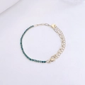 Macro shot of 18K gold plated stainless steel bracelet with green zircon inlay and clasp - Gold / Green Rhinestone