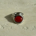 Macro detail of polished silver titanium ring with an oval reddish-brown gemstone inlay - US 6 / Silver with Red Stone