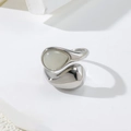 Macro shot of silver teardrop stone ring with minimalist organic streamline design - Silver + White
