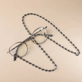 Detail of acrylic eyeglass chain with marble texture and adjustable silicone loops - Transparent Black and White (GC008_3)