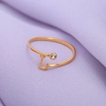 Verstelbare gouden ring met letter L en een zirkoniasteen op paarse stoffen achtergrond - Goud-L