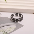 Detalle macro de un anillo de resina transparente con un diseño de cara sonriente negra - Negro