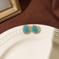 Detailaufnahme der Vintage Smaragd Zirkon Ohrstecker auf elegantem Keramiktablett - Ovaler Seeblauer Zirkonia (Silberstift)