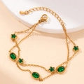 Elegant gold double-layer bracelet with green star and oval gemstones on stone tray - Star and Oval Style