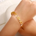 Detailed close-up of a two-tone heart chain bracelet with pave zircons on woman's wrist - Hollow Heart Link Style (SZ-001)