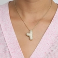 Pendentif lettre Y doré bouffant avec zircons pavés sur un pull en maille rose - Collier Y