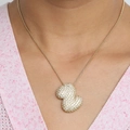 Collier doré avec double cœur serti de cristaux porté par un mannequin - Collier Z