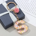 Porte-clés lettre S en résine pailletée avec étoiles colorées et pompon rose décoratif - S