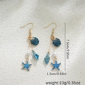 Détail des boucles d'oreilles en or 14K avec breloques coquillage bleu et étoile - Bleu