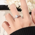 Detailansicht eines V-förmigen Silberrings mit rundem Zirkonia-Stein am Finger - US 5 / Silber