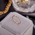 Detalle de anillo de 1mm en oro rosa con textura facetada sobre estuche de terciopelo - US 4 / Rosa oro