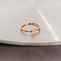 Detailed view of rose gold daisy ring with white enamel flower on metal background - US 4 / White