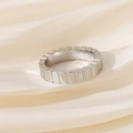 Dettaglio di un anello d'argento con scanalature verticali su seta color crema - US 5 / Argento