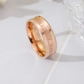 Detail eines roségoldenen Titanrings mit graviertem 'BE THE CHANGE' Text in der Mittelnute - US 5 / Roségold