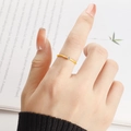Nahaufnahme eines schmalen goldenen Zirkonrings am Finger vor Lifestyle-Hintergrund - US 5 / Gold mit weißem Zirkon