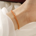 Minimalist red woven bracelet with gold titanium steel beads shown on a model's wrist - Gold Red String