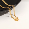 Macro shot of 24K gold plated Figaro chain necklace showing detailed M-clasp and texture - Figaro Chain / Gold