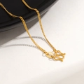 Close-up of a 24K gold-plated M-clasp and engraved tag on a titanium steel chain necklace - Polished Chain Necklace / Gold