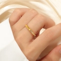 Nahaufnahme eines Goldrings aus Titanstahl mit Pyramidennieten und halbem Diamantbesatz - US 5 / Gold