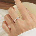 Nahaufnahme eines minimalistischen Titanstahlrings mit Zirkonia-Solitär an einem Frauenfinger - US 5 / Stahlfarben