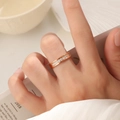 Nahaufnahme eines 18K vergoldeten Titanrings mit funkelndem Zirkonia-Besatz am Finger - US 5 / Roségold