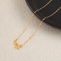 Golden titanium water wave chain necklace with elegant M-clasp on ceramic tray - Satellite Chain / Gold