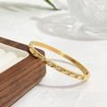 Gold plated titanium steel bangle with inlaid zircons on a walnut jewelry display - Checkered Zircon Style