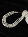 Collar de tres capas de perlas crema con cierre dorado sobre fondo de terciopelo negro - Collar de 8.0mm