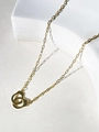 Macro view of 18K gold-plated handcuff pendant with paperclip chain on white stone - Gold