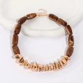 Detail of brown marble resin cylinder beads and golden geometric metal charms on necklace - Gold Metal / Brown
