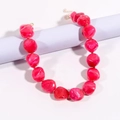 Detailed macro view of red marble textured irregular stone necklace with gold metal links - Rose Red