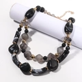 Detail of chunky double-layer necklace with marbled resin beads and golden spacers - KC Gold / Black